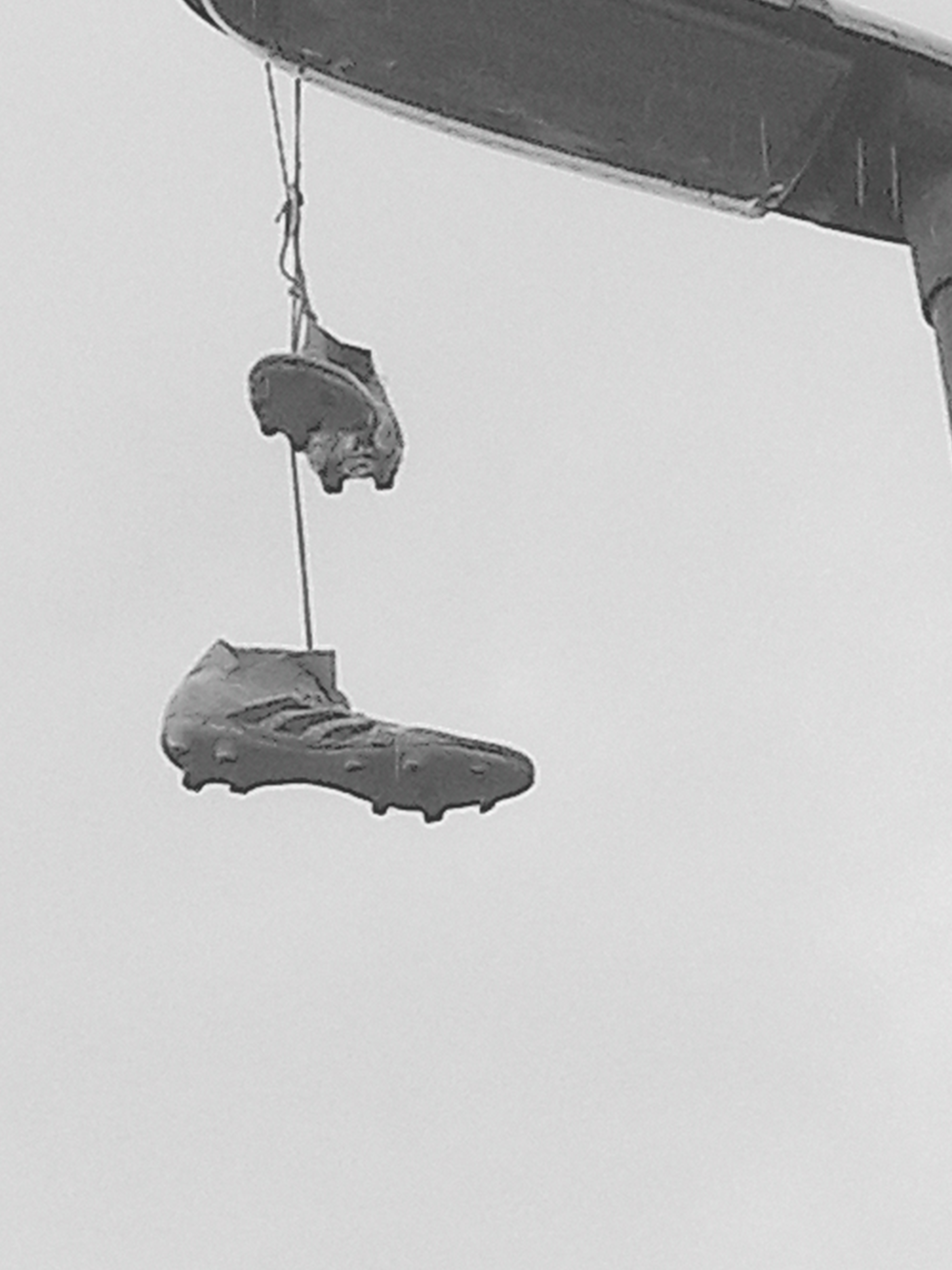 Photo of running shoes hanging from a streetlamp